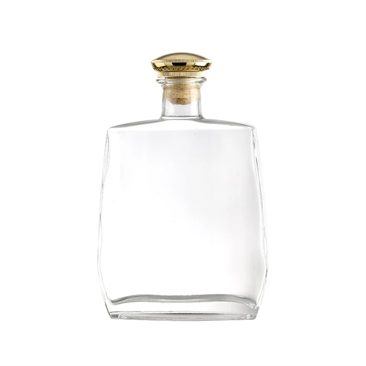 Botella de vidrio transparente con tapa dorada sencilla